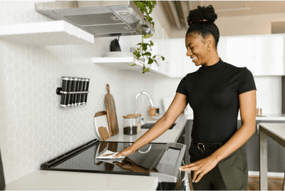 lady smiling while cleaning stove top